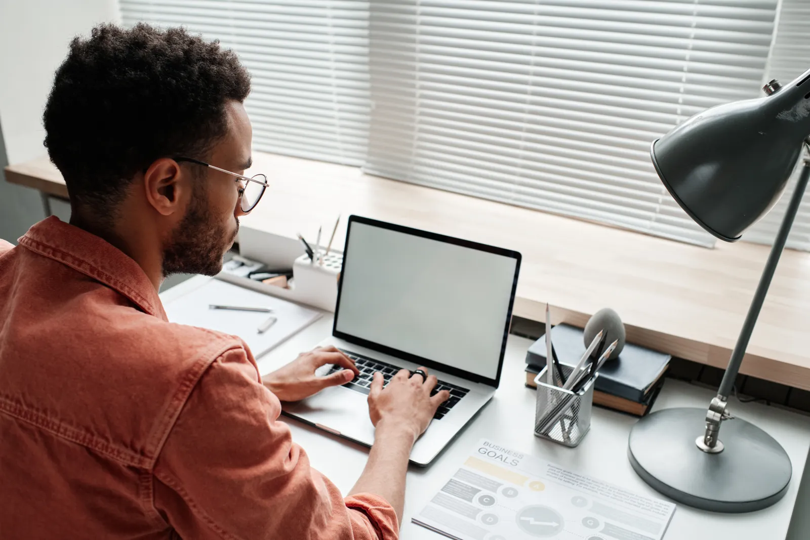 Man working on a laptop at a bright desk, reviewing search results