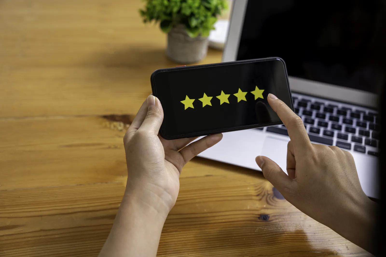 Hands holding a phone showing a five-star rating